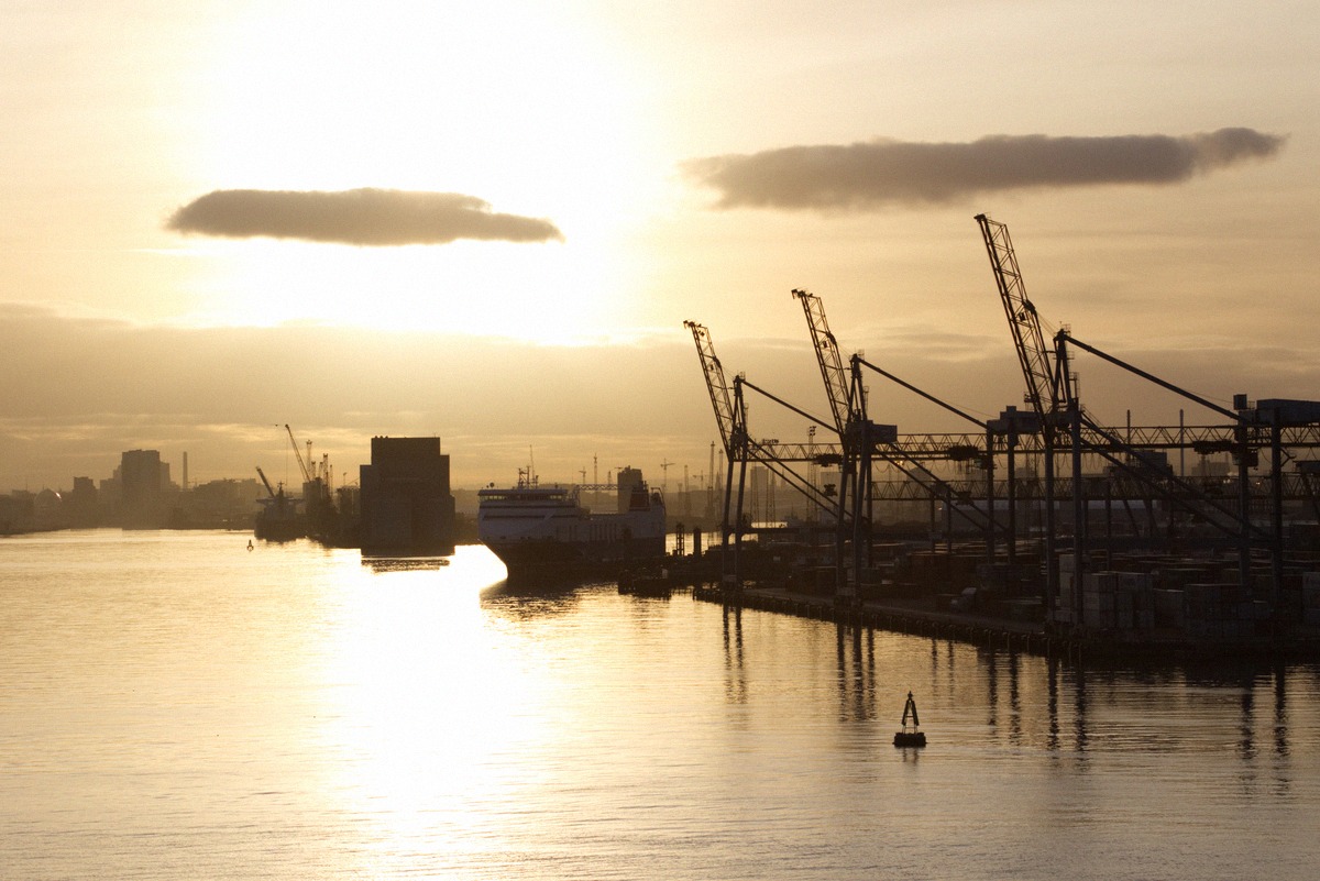 A ferry at the pier in Belfast Harbour behind the loading cranes